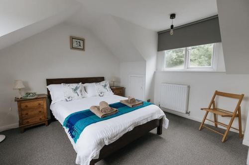 - une chambre avec un lit avec deux chapeaux dans l'établissement OAKERTHORPE COTTAGE - Countryside Cottage near the Peaks District National Park, à Wirksworth