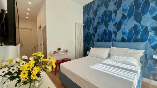 1 dormitorio con 1 cama y un jarrón de flores en Sea Glimpse Studio - Santa Lucia, en Nápoles