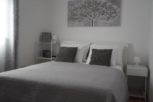 a bedroom with a white bed with two pillows at House KID in Bribir