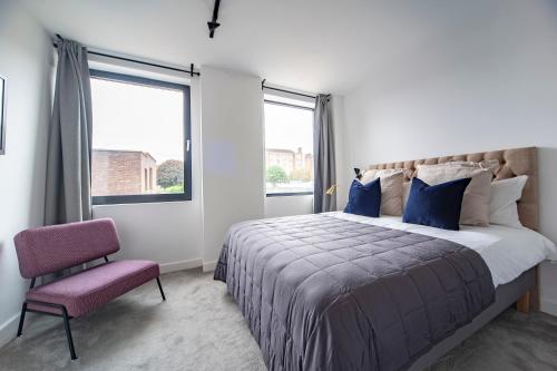 a bedroom with a large bed and a chair at Charming 1Bed Apt with Balcony - Steps from Tube in London
