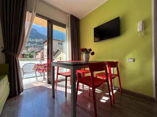 una sala da pranzo con tavolo e sedie e un balcone di Gardesana Active Apartments a Malcesine
