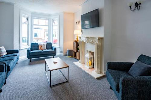 Una sala de estar con dos sofás y una chimenea. en Touchwood House Llandudno, en Llandudno