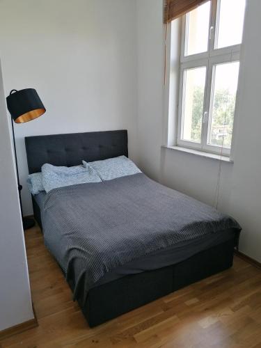 a bed in a white room with a large window at Zwei Charmante Privatzimmer mit Wohnbereich in zentraler Berliner Wohnung in Berlin