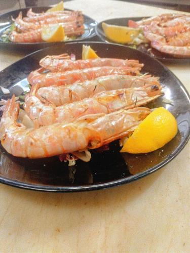 a plate of shrimp with a lemon on a table at Hotel Ristorante Stella in Palestrina