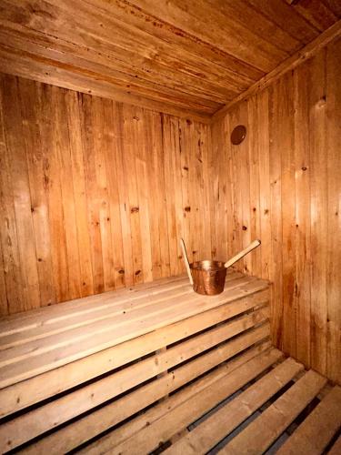a small wooden sauna with a bucket in it at 5 Hálószobás Wellness VIP House - privát medence in Siófok
