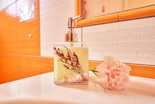 a bottle of soap sitting on a counter next to a flower at Apartmány Eva in Janske Lazne