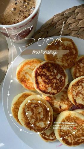 Een bord met pannenkoeken en een kop koffie. bij SULTANAT Samarkand in Samarkand