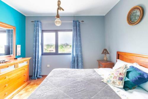 a bedroom with a bed with blue walls and a window at Villa Clementina in Barcelos