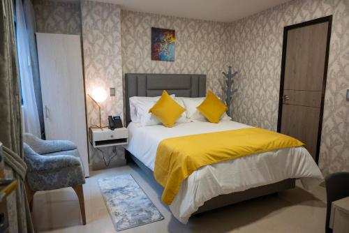 a bedroom with a bed with yellow sheets and a chair at BLISS BOUTIQUE HOTEL BOGOTA in Bogotá