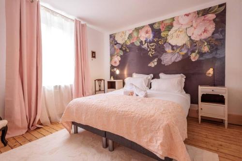 a bedroom with a large bed with a floral wall at La maison du lac du Grobon in Châtillon-sur-Chalaronne