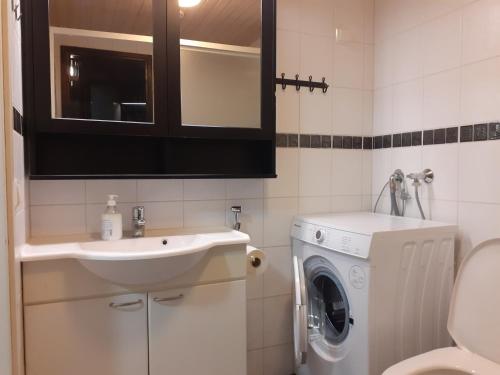 La salle de bains est pourvue d'un lavabo et d'un lave-linge. dans l'établissement Apartment Vuokatin Taika 2, à Vuokatti