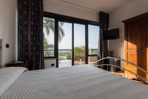 a bedroom with a bed and a large window at Villa Il Torchio in Messina