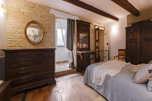 a bedroom with a bed and a dresser and a mirror at [Luxury House] Palazzo Signorile in Centro in Civitanova Alta