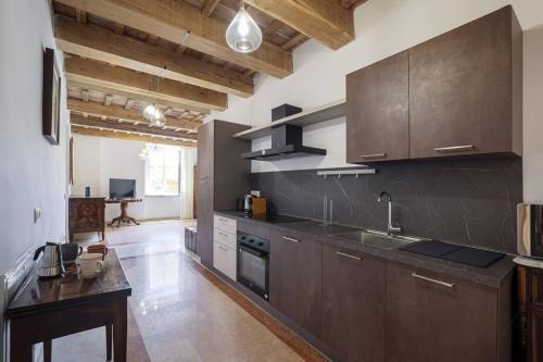 a large kitchen with brown cabinets and a sink at [Luxury House] Palazzo Signorile in Centro in Civitanova Alta