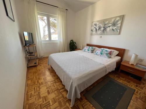 1 dormitorio con 1 cama con 2 almohadas en Apartmani Bosiljka en Nin