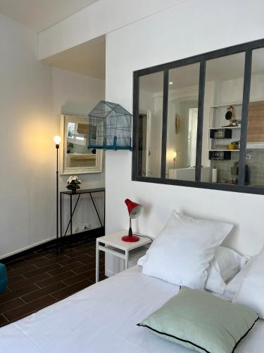 une chambre avec un lit blanc et un miroir dans l'établissement 