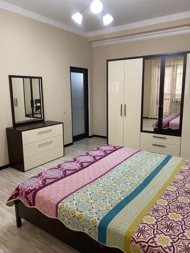 a bedroom with a bed and a dresser and a mirror at ЖК Томирис 2 комнатная квартира in Atyrau