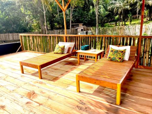 two wooden benches sitting on a wooden deck at Infinity-house with roof terrace and direct access to the beach in Santana