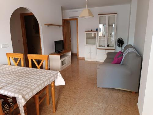 ein Wohnzimmer mit einem Sofa und einem Tisch in der Unterkunft El Roalico in Los Alcázares