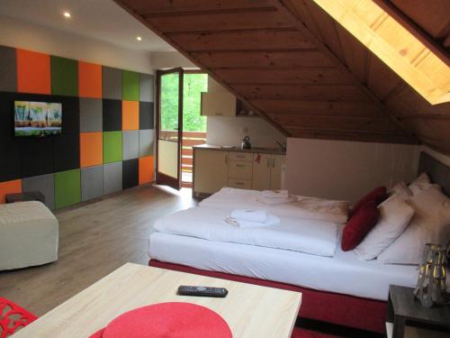 a bedroom with a large bed and a kitchen at Apartamenty Lawenda in Rabka
