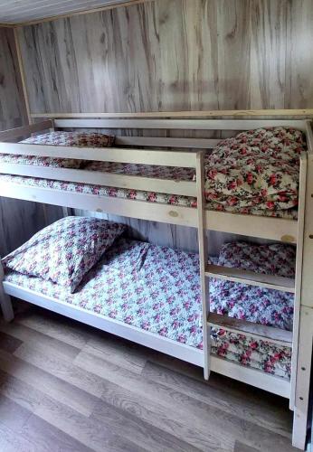 twolevel bunk beds in a room with a wooden wall at Mały domek w centrum Rowów in Rowy