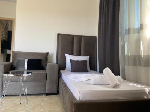 a bedroom with a bed and a couch at Villa Bodini Himare in Himare