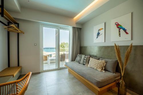 a living room with a couch and a large window at Alexia Beach Hotel in Agia Marina Nea Kydonias