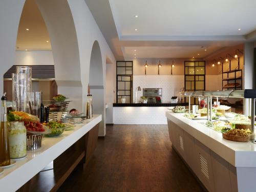 a restaurant with a buffet line with food on display at MarBella, Mar-Bella Collection in Agios Ioannis Peristeron