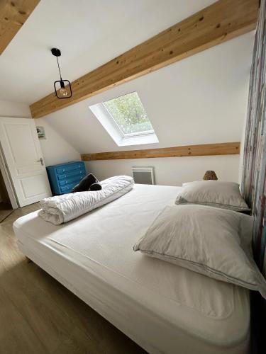 - une chambre avec un grand lit blanc et une lucarne dans l'établissement Le Clos de l'Angley Gîtes et Écurie, à Caffiers