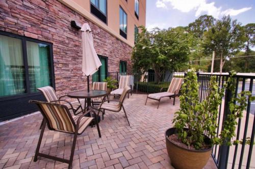 a patio with a table and chairs and an umbrella at Hampton Inn & Suites Jacksonville Beach Boulevard/Mayo Clinic in Jacksonville