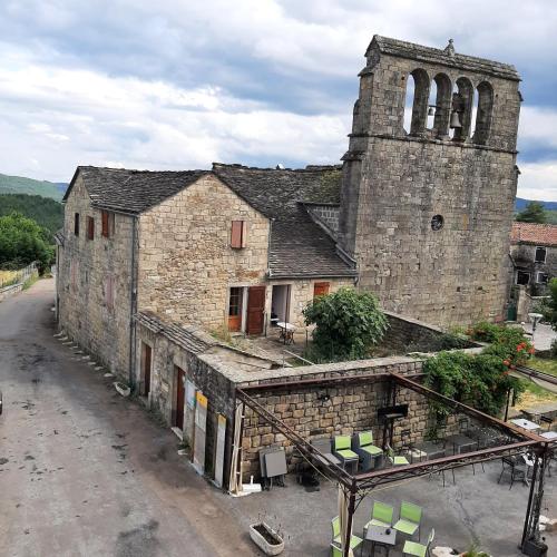 an old stone building with a tower and a church at LE SECRET D'AUJAC in Aujac