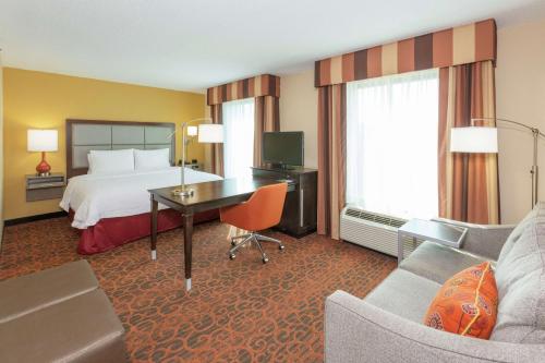 a hotel room with a bed and a desk at Hampton Inn & Suites Jacksonville-Airport in Jacksonville