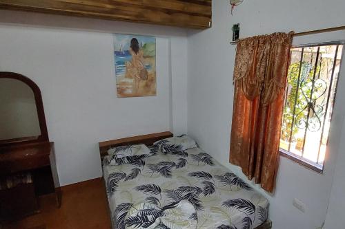 a bedroom with a bed in a room with a window at HOTEL CASA COLONIAL in San Antonio del Táchira