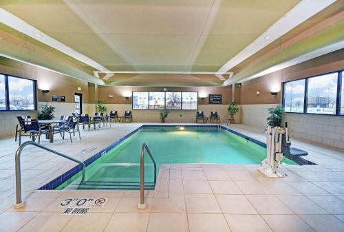una piscina con mesas y sillas en un edificio en Hampton Inn Beloit, en Beloit