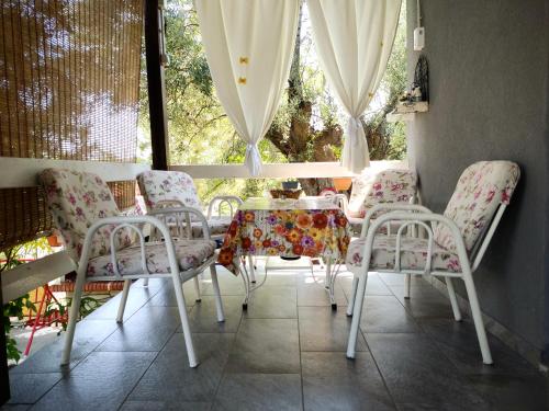 jadalnia ze stołem i krzesłami oraz oknem w obiekcie Jenny's House w mieście Yerakiní