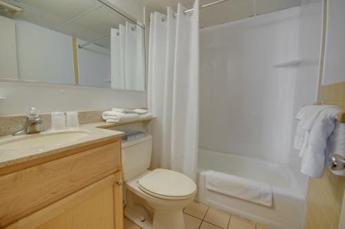 a bathroom with a toilet and a sink and a mirror at Flamingo Motel in Ocean City