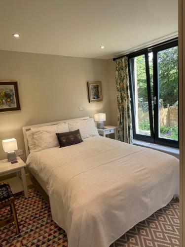 1 dormitorio con cama grande y ventana grande en Garden hideaway, self-contained, edge of Bath en Bath