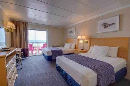 a hotel room with two beds and a balcony at Flamingo Motel in Ocean City