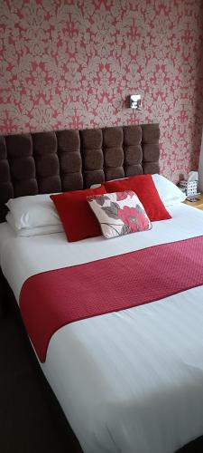 a bedroom with a large bed with a red blanket at Lawnswood Guest House in Torquay