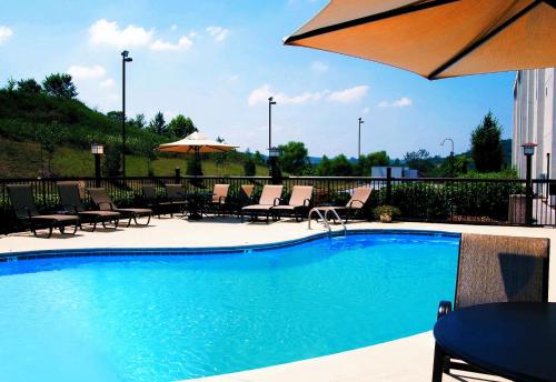 a large swimming pool with chairs and an umbrella at Hampton Inn Kingsport in Kingsport