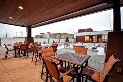 a patio with tables and chairs and a building at Homewood Suites by Hilton Kalispell in Kalispell