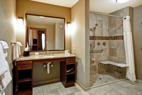 uma casa de banho com um chuveiro, um lavatório e um chuveiro em Homewood Suites by Hilton Kalispell em Kalispell