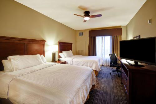 a hotel room with two beds and a flat screen tv at Homewood Suites by Hilton Kalispell in Kalispell