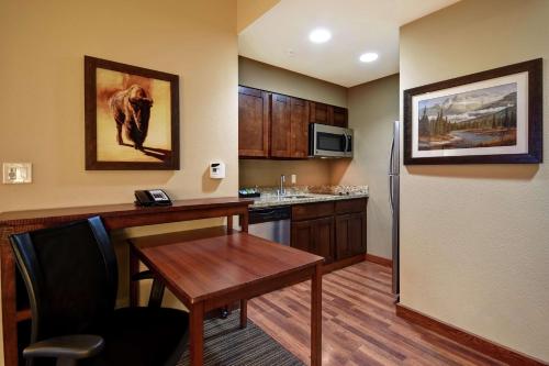 a small kitchen with a table and a refrigerator at Homewood Suites by Hilton Kalispell in Kalispell
