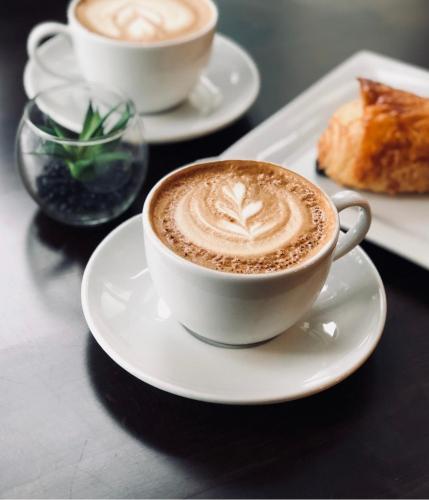 a cup of coffee on a plate on a table at Perla e Dumrese, Bar-Restaurant-Hotel in Belsh