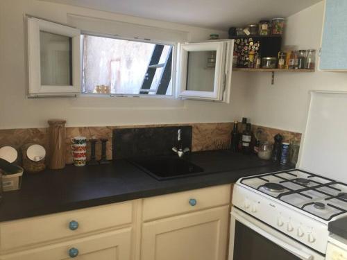 a kitchen with a sink and a stove and a window at La petite maison et ses quatre vélos in Rezé