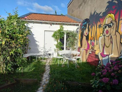 een muurschildering aan de zijkant van een gebouw met een tafel bij La petite maison et ses quatre vélos in Rezé