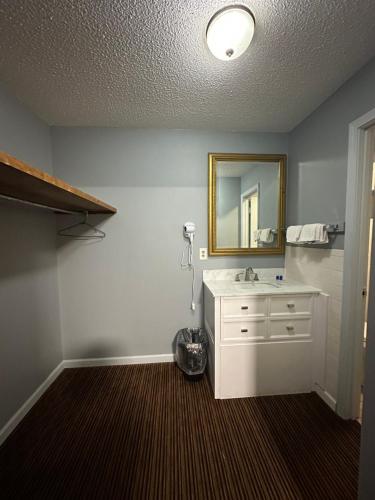 a bathroom with a white sink and a mirror at Rodeway Inn & Suites in Walhalla