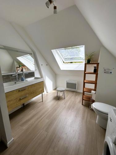 La salle de bains mansardée est pourvue d'un lavabo et de toilettes. dans l'établissement Le Clos de l'Angley Gîtes et Écurie, à Caffiers
