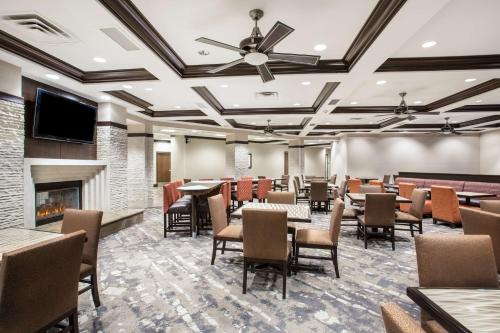 a dining room with tables and chairs and a fireplace at Homewood Suites by Hilton South Las Vegas in Las Vegas